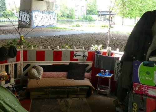 Auf dem Foto ist Björns selbst eingerichtete Ecke zu sehen. In dieser Perspektive mit einem kleinen Sofa, Klamotten und Kartons.